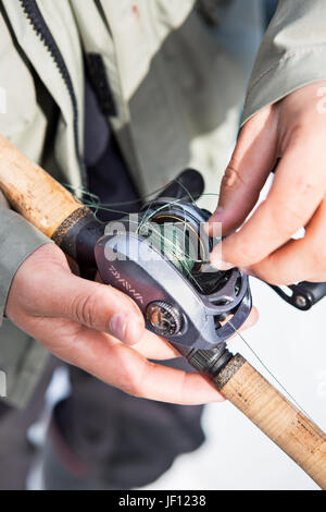 L'uomo untangling lenza sull'aspo, close-up Foto Stock