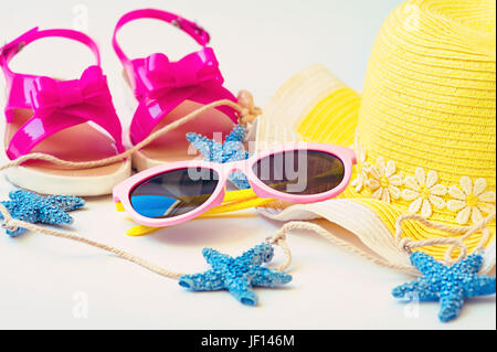 Cappello di paglia, asciugamano, occhiali da sole e flip flop su sfondo bianco Foto Stock