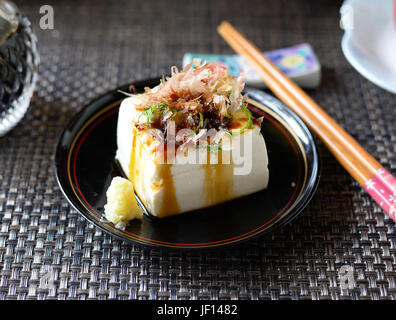 Primo piano della hiyayakko--giapponese FREDDI Insalata di tofu--su uno sfondo nero. Foto Stock