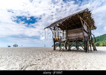 Un paio di rough-cercando, capanne di legno stand isolata sulla spiaggia Annora, una graziosa spiaggia deserta in Indonesia. Foto Stock