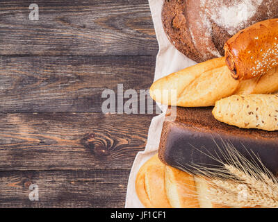 Assortimento di pane marrone su sfondo di legno Foto Stock
