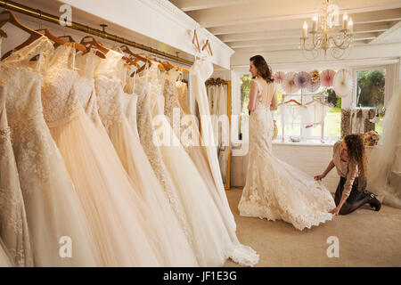 Righe di abiti da sposa sul display in uno specialista abito da sposa shop. Foto Stock