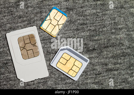 Serie di mini e micro e nano simcard. Isolato su tessuto grigio Sfondo texture Foto Stock