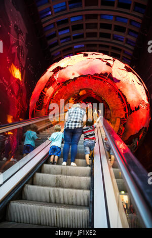 Famiglia in Escalator passando attraverso il Pianeta Terra in un Museo di Storia Naturale di Londra Foto Stock