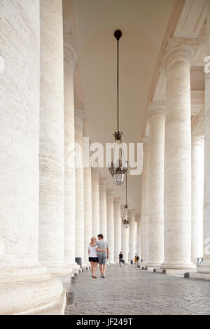 Giovane a piedi attraverso il colonnato Foto Stock