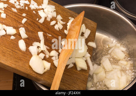 Mettere la cipolla in una padella Foto Stock