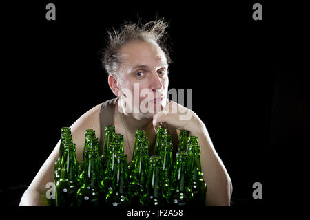 La felice ubriaco uomo vicino a svuotare le bottiglie di birra Foto Stock