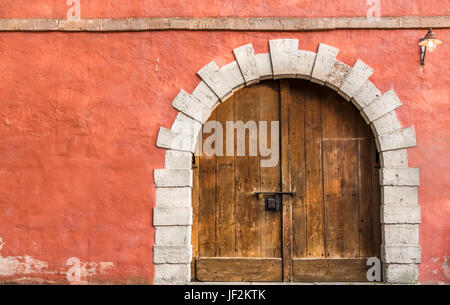 In legno porta medievale e la parete arancione Foto Stock