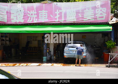 Persona lavaggi di mini van durante le calde estati giorno nella nuova città di Taipei, Taiwan lavora nella propria azienda. Foto Stock
