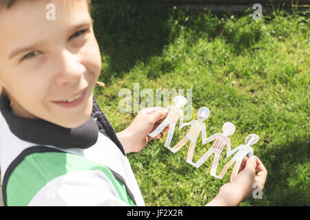 Bambino tenere la carta fatta di persone nelle figure Foto Stock