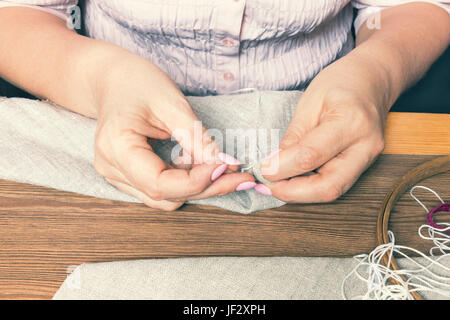 Donna mani facendo openwork ricamo Foto Stock