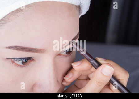 Close-up donna utilizzando una matita per le sopracciglia per il trucco Foto Stock