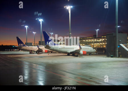 OSLO, Norvegia - JAN 21st, 2017: La Lufthavn Oslo Airport Gardermoen OSL è il principale aeroporto della Norvegia e un hub per la compagnia aerea a basso costo Norwegian Air Shuttle DY e SAS Scandinavian Airlines SK . Boeing 737 in corrispondenza del cancello druing la mattina presto Foto Stock