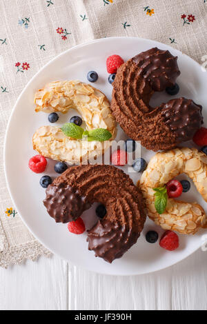 Festosa e mandorle e biscotti al cioccolato a forma di ferro di cavallo vicino sul tavolo. Vista verticale da sopra Foto Stock