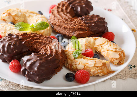 Bella biscotti frollini con il ferro di cavallo e il cioccolato e le mandorle di close-up su una piastra orizzontale. Foto Stock