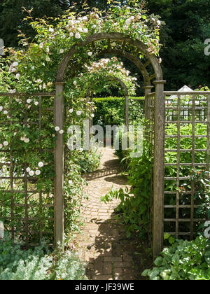 Round sormontato in legno archi di rose e trellis su giardino percorso, Barnsdale Gardens, Oakham, Rutland, REGNO UNITO Foto Stock