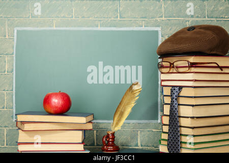 Jesting insolita insegnante, libri, quill penna, Apple prima di lavagna con spazio di copia Foto Stock