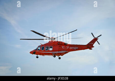 Ornge Air Ambulance in volo contro un cielo blu con una sottile copertura nuvolosa Foto Stock