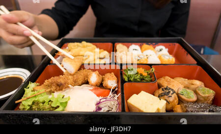 Le donne mangiare bento box set nel ristorante giapponese Foto Stock