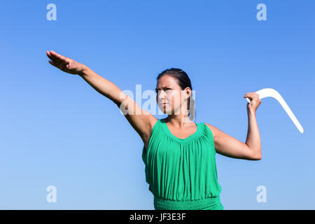 Donna olandese gettando boomerang nel cielo blu Foto Stock