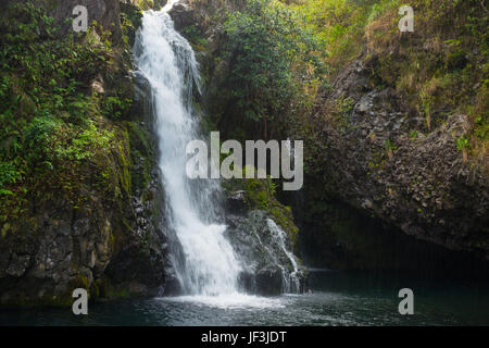 Una cascata a fianco della strada a Hana sull'isola hawaiana di Maui. Foto Stock