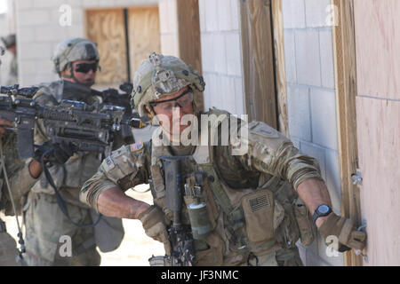 Una seconda brigata corazzate contro la squadra, 1a divisione di fanteria, soldato si prepara per la violazione di una porta con il suo team di fuoco durante un attacco su una simulazione di ambiente urbano presso il National Training Center a Fort Irwin, California, 4 maggio. (Sgt. Michael C. Roach, XIX Affari pubblici distacco) Foto Stock