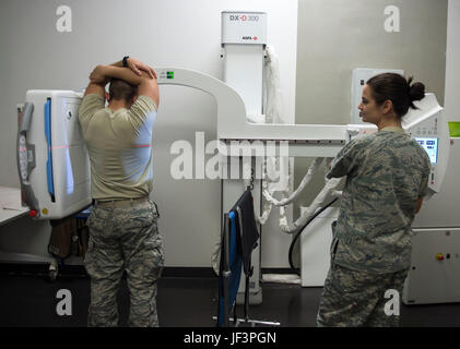 Stati Uniti Air Force Staff Sgt. Jessica Corley, a destra di un x-ray e tecnico ad ultrasuoni con il 379 Expeditionary operazioni mediche Squadron, esegue un test x-ray su un aviatore Al Udeid Air Base, Qatar, 15 maggio 2017. Il programma di radiologia aiuta la cura primaria Clinica con diagnosi di lesioni sospette o lesioni interne utilizzando la macchina a raggi x o la scansione TC del corpo. (U.S. Air Force foto di Tech. Sgt. Amy M. Lovgren) Foto Stock