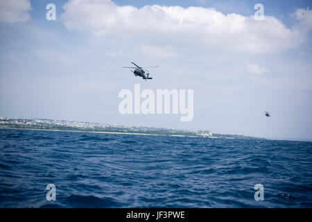 Stati Uniti Air Force HH-60G spianare i falchi dal XXXIII Rescue Squadron, Kadena Air Base, consegnare gli avieri dal 320Tattiche speciali squadrone di un le operazioni anfibie formazione zona di caduta 18 maggio 2017, al largo della costa occidentale di Okinawa, in Giappone. Tattiche speciali team aviatori sono organizzati, addestrati e dotati di condurre operazioni speciali compiti fondamentali durante ad alto rischio in operazioni di combattimento. (U.S. Air Force foto di Senior Airman Omari Bernard) Foto Stock