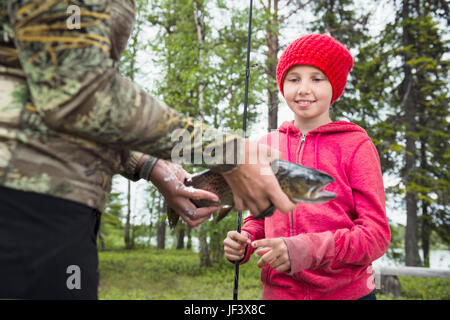 Ragazza guardando i pesci tenendo da donna Foto Stock