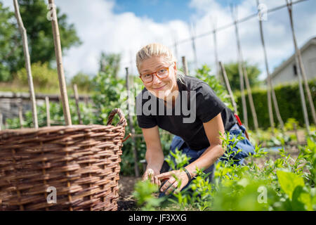 Giovane donna lavora in giardino Foto Stock