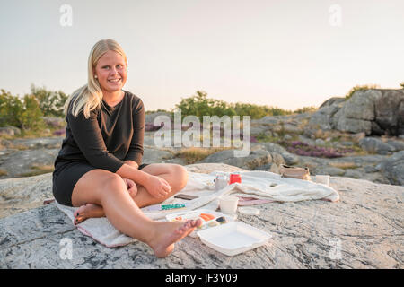 Ragazza adolescente avente picnic sulla roccia Foto Stock