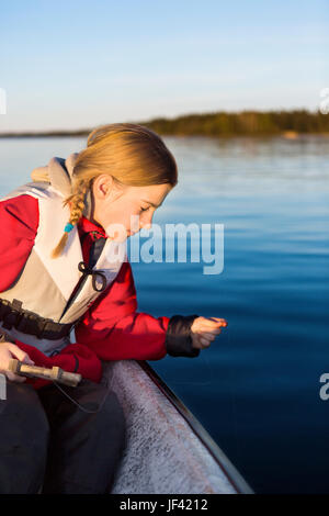 Ragazza adolescente la pesca in barca Foto Stock