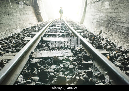 Bambino a camminare nel tunnel ferroviario Foto Stock