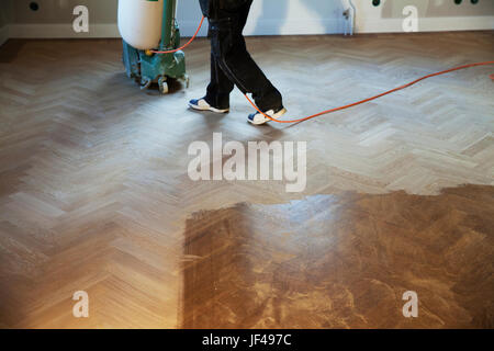 Uomo di pulizia pavimento in legno con piano lucidante Foto Stock