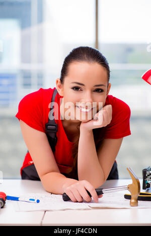 Giovane donna in tute le riparazioni facendo Foto Stock