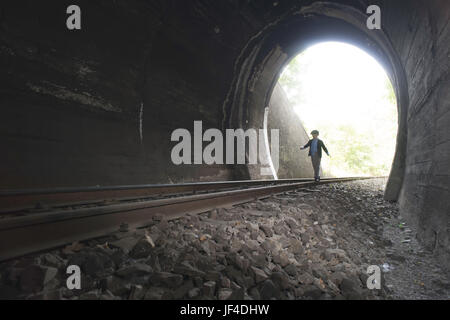 Bambino a camminare nel tunnel ferroviario Foto Stock