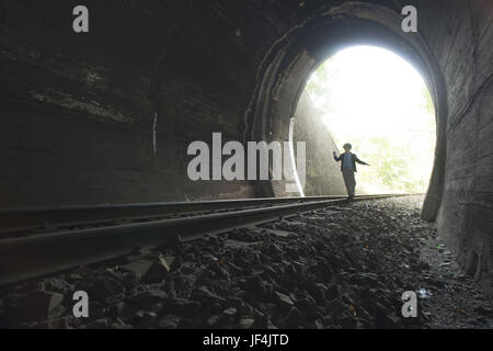 Bambino a camminare nel tunnel ferroviario Foto Stock