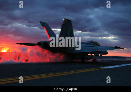 Un F/A-18F Super Hornet è catapultato fuori della lotta del ponte della portaerei USS Dwight D. Eisenhower CVN (69) durante il tramonto operazioni di volo. DoD foto di Airman Christopher Molinari U.S. Navy Foto Stock