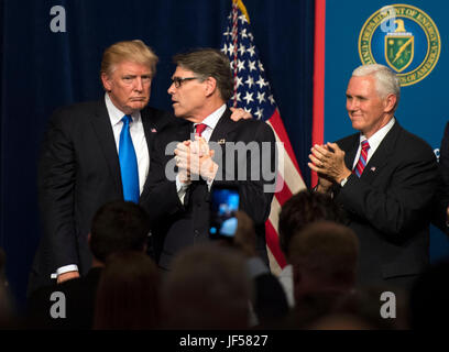 Il Presidente degli Stati Uniti, Trump (L) abbraccia il Segretario dell'energia Rick Perry come Vice Presidente Mike Pence applaude (R), dopo Trump consegnato commento su a liberare energia Americano evento presso il Dipartimento di Energia di Washington il 29 giugno 2017. Trump ha annunciato un numero su iniziative tra cui la sua amministrazione del piano di laminazione sul retro dei regolamenti sulla produzione di energia e sviluppo. Credito: Kevin Dietsch/Piscina via CNP /MediaPunch Foto Stock