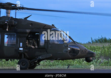 Un Maryland Guardia Nazionale UH-60 Blackhawk equipaggio dal 224th reggimento aviazione attende di essere liquidati per il decollo a Camp Wainwright, Alberta, Canada, il 26 maggio 2017. Sono state lavorando con il Royal Canadian Air Force 450 elicotteri tattici squadrone di inserire le truppe in battaglia spazio durante il Maple risolvere 17, l'esercito canadese di premier di brigata di convalida a livello di esercizio, progettato per affinare le abilità individuali migliorando al contempo l'interoperabilità. Foto Stock