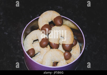 Lo stagno pieno di burro di Natale biscotti immersi nel cioccolato Foto Stock