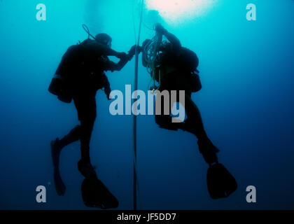 Utilitiesman 2a classe Erick Martin e costruzione elettricista 2a classe Greg Lewis, assegnato alla costruzione subacquea Team (UCT) 2, prepararsi a rig un profondo acqua boa di ormeggio in Apra Harbor al largo di Guam Maggio 31, 2017. UCT 2 fornisce ottime inshore sottomarino e capacità di costruzione sotto la guida del comandante, Task Force 75. Essi sono in grado di costruire, ispezionare, riparare e manutenere ocean impianti nonché sistemi subacquei. (U.S. Navy combattere la foto della telecamera tramite la comunicazione di massa specialista di terza classe Alfred A. Coffield) Foto Stock