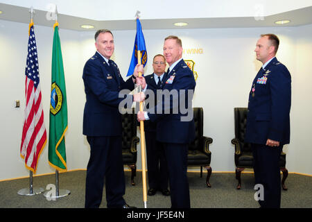 Col. Larry Hager, il comandante in entrata del Washington Air National Guard 194th della missione del gruppo di supporto, assume la missione del gruppo di supporto guidon da Col. Gent gallese, comandante della 194th ala, durante un cambio del comando cerimonia al Camp Murray, in data 1 giugno. Missione in uscita del gruppo di supporto commander Col. Johan Deutscher, che prenderà il comando del Washington Air National Guard's 141Air Refuelling Wing, guarda a destra. Master Sgt. Eric Baillie sorge in background. Foto Stock