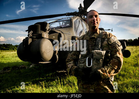 Un Chief Warrant Officer del 1st Battalion, 3rd Attack Regiment, US Army, si trova con un elicottero AH-64 Apache dopo un volo transeuropeo di supporto all'esercitazione Noble Jump 2017. Foto Stock