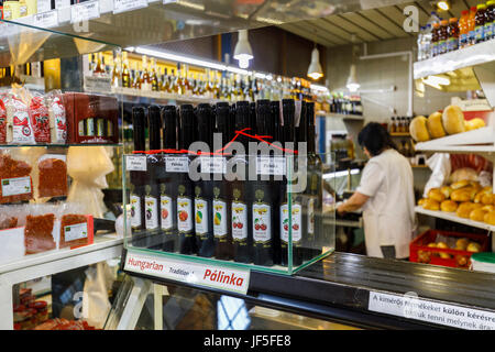 Pressione di stallo all'interno del coperto Mercato Centrale (Vasarcsarnok), display di bottiglie di frutta tradizionali grappa aromatizzata, Pest, Budapest, Ungheria Foto Stock