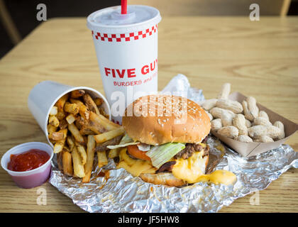 Un bacon cheeseburger, le patatine fritte e arachidi da cinque ragazzi hamburger e patatine fritte, un American fast informale ristorante della catena. Foto Stock