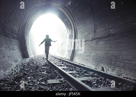 Bambino a camminare nel tunnel ferroviario Foto Stock