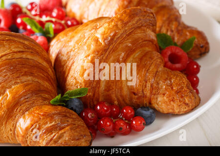 Bella la pasticceria: cornetti e bacche di close-up su una piastra orizzontale. Foto Stock