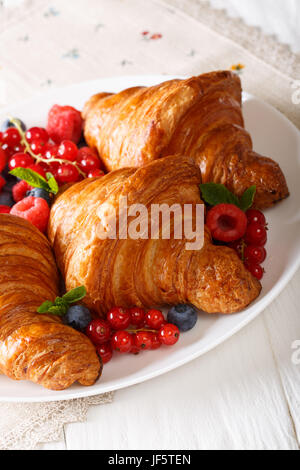 Deliziosi cornetti fatti in casa e bacche di close-up su una piastra verticale. Foto Stock