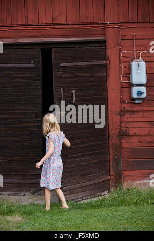 Ragazza apertura porta del granaio Foto Stock